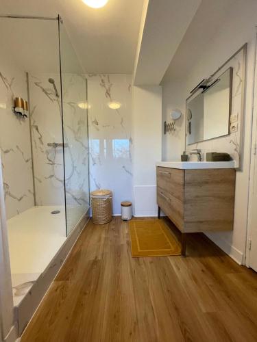 a bathroom with a sink and a glass shower at Maison de campagne 110m2 in Longeault