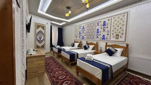 a room with four beds with blue and white at Hotel Al Amir palace boutique in Bukhara