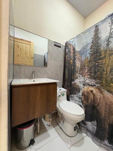 a bathroom with a toilet and a bear shower curtain at Apartment Nazareth in La Unión