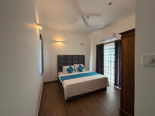 a bedroom with a bed with blue pillows at Colombo lotus tower view Apartment in Colombo