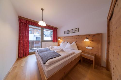 a bedroom with a bed and a large window at Appartement-Edelweiss in Altenmarkt im Pongau