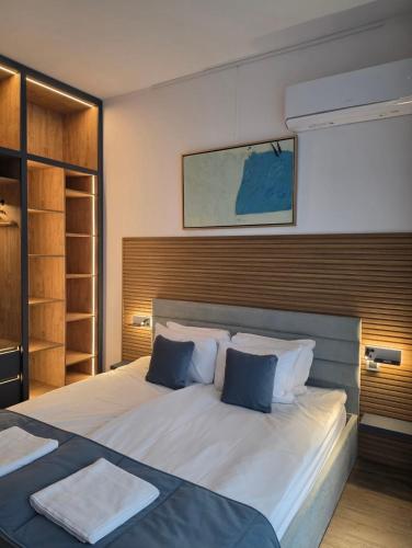 a bedroom with a large white bed with blue pillows at Oblivion 1 in Velingrad