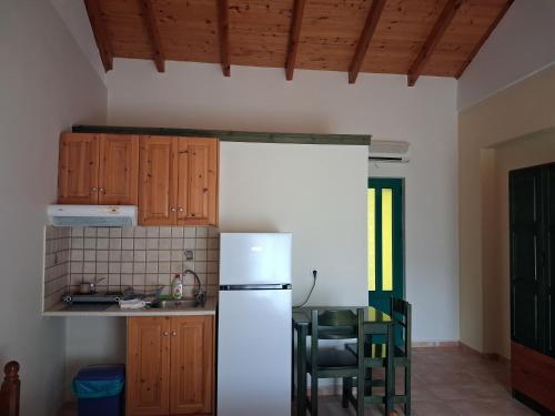a kitchen with a refrigerator and a table and chairs at Lenia Studios in Kalamitsi