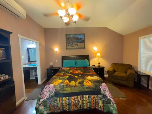 a bedroom with a bed and a chair in it at Cabin 4 The Roost Cabins in Lakehills