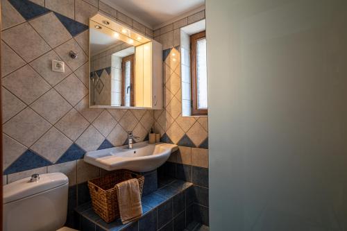 a bathroom with a sink and a toilet and a mirror at Villa Aethra in Riglia