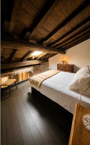 a bedroom with a large bed and a wooden ceiling at Casa do Tio Zé Montesinho in Montezinho