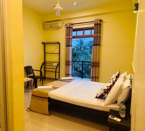 a bedroom with a bed and a window at Goldern Gate in Kandy