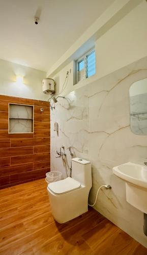 a bathroom with a toilet and a sink at Ayaf Homes in Pondicherry