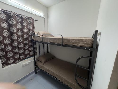 a small room with two bunk beds and a curtain at Udupi Shri Krishna Dormitary Bed Space in Udupi