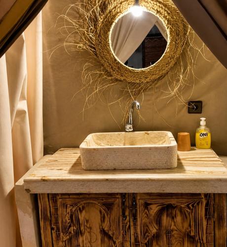 a bathroom with a sink and a mirror at Tranquil gem luxury camp in Merzouga