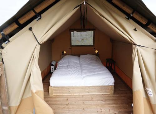 ein Schlafzimmer in einem Zelt mit einem Bett darin in der Unterkunft F1 Spa 2026 Circuit 2p Parking Dopey in Amel