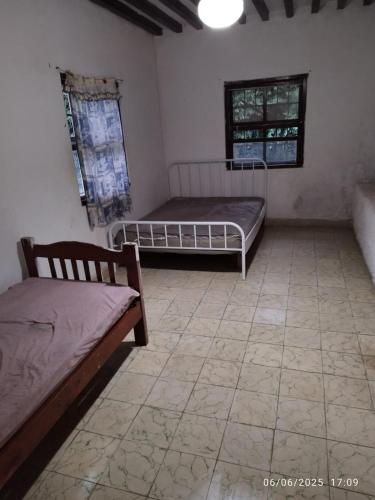 a room with two beds and a tiled floor at Chácara Volito in Cotia