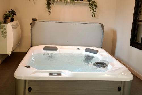 a bath tub with a sink in a bathroom at La chambre du moulin dort in Chénelette
