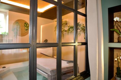 a glass window with a table in a room at La chambre du moulin dort in Chénelette