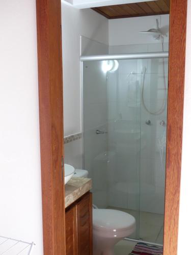 a bathroom with a shower and a toilet and a sink at Flats No Sushi in Itacaré