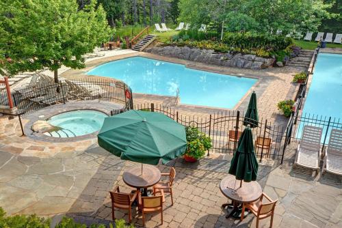 an overhead view of a pool with tables and an umbrella at Tremblant Prestige - Les Eaux 215-8 in Mont-Tremblant