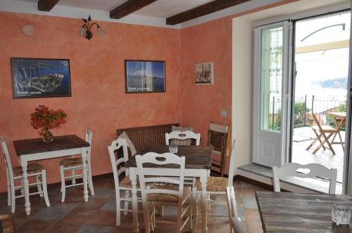 comedor con paredes de color naranja, mesa y sillas en B&B Il Feriolo, en Baveno