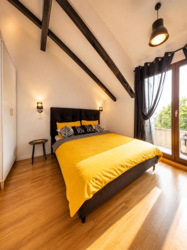 a bedroom with a bed with a yellow blanket at Sea house Lea in Novi Vinodolski