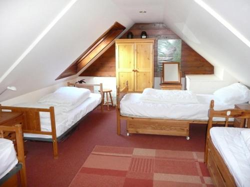 a attic room with two beds and a staircase at Scoor - Garden Cottage in Bunessan