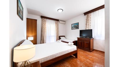 a hotel room with a bed and a television at Villa MD in Budva