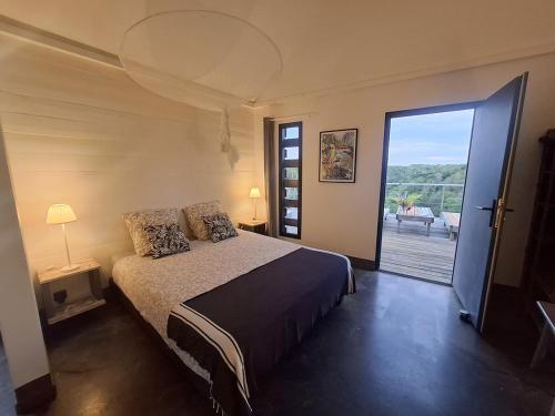 a bedroom with a bed and a sliding glass door at La Case des Caraïbes in Le Gosier