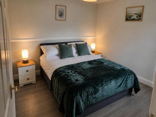 a bedroom with a bed with two night stands and two lamps at Katie's Cottage in Laghy