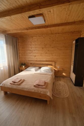 a bedroom with a bed with two towels on it at Гостинний двір in Vorokhta