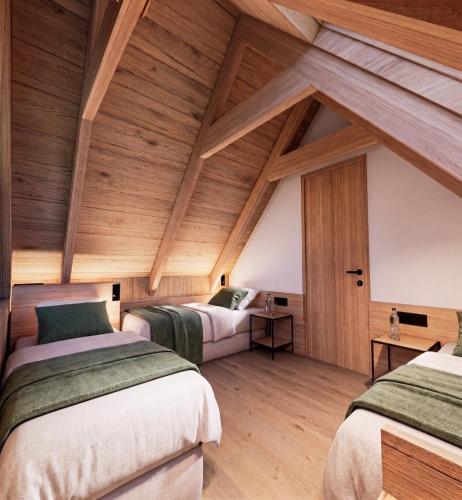 two beds in a room with wooden ceilings at Bungalows Verneda Mountain Resort in Arrós