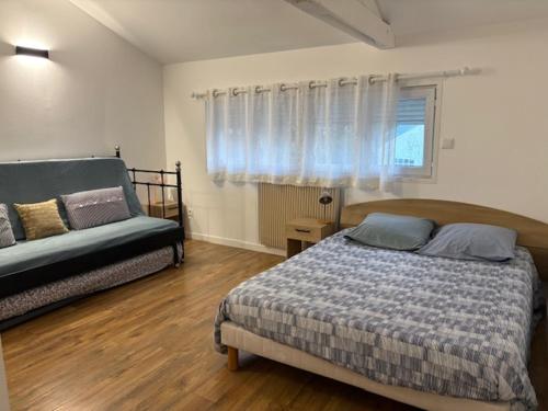 a bedroom with a bed and a couch at Marne appartements in Nogent-sur-Marne