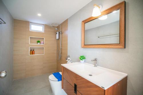 a bathroom with a sink and a toilet and a mirror at SunRise Beachfront Cha am in Ban Bang Ket