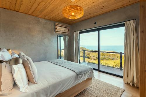 a bedroom with a large bed and a large window at Casa da Rocha in Terra Alta