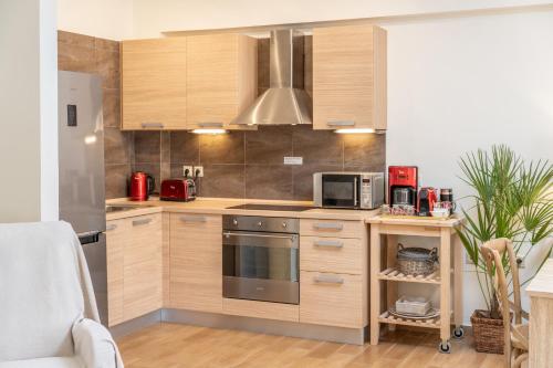 a kitchen with wooden cabinets and a stainless steel appliance at Nefeli Duplex Apartment in Karavomylos