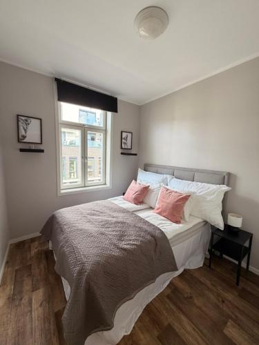 ein Schlafzimmer mit einem großen Bett und zwei rosa Kissen in der Unterkunft Harmony in Oslo