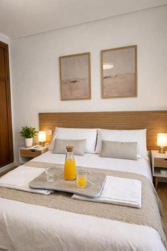 a hotel room with a bed with a tray of orange juice at Entre Plazas in Cáceres