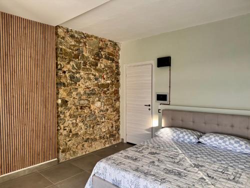 a bedroom with a bed and a stone wall at Residenza 33 in Torchiara