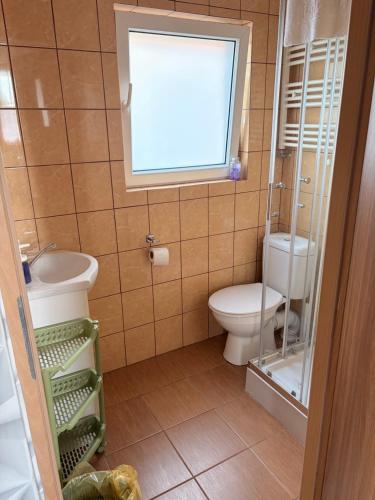 a bathroom with a toilet and a sink and a window at U Marzeny in Malbork