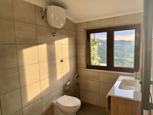 a bathroom with a toilet and a sink and a window at Residenza 33 in Torchiara