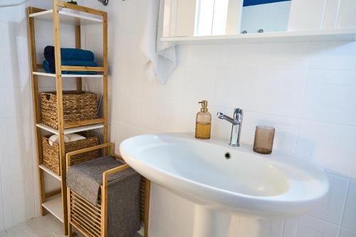 a bathroom with a sink and a shelf with towels at Lagoon Dream in Fanari