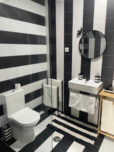 a black and white bathroom with a toilet and a sink at Salina Ria Studio 2 in Aveiro