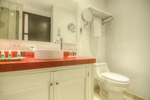 a white bathroom with a sink and a toilet at Hotel Monterrey in Cartagena de Indias