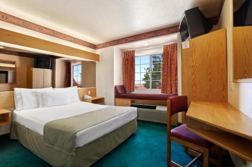 a hotel room with a bed and a desk at Microtel Inn & Suites by Wyndham Albuquerque West in Albuquerque