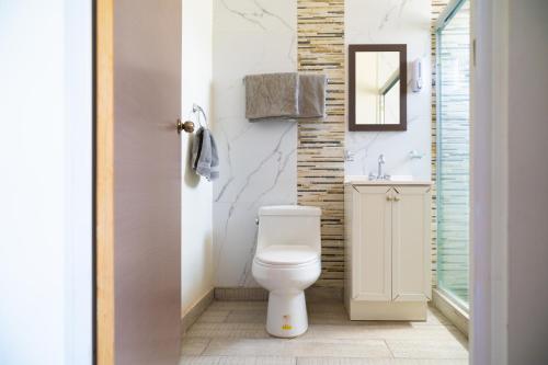a bathroom with a white toilet and a sink at Santa Elena 400 in Torreón