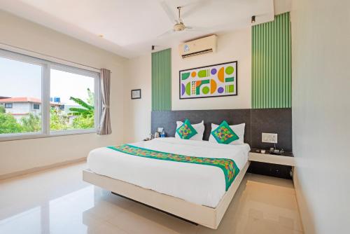a bedroom with a large bed and a window at Treebo Kuber Palace with Swimming Pool in Mahabaleshwar