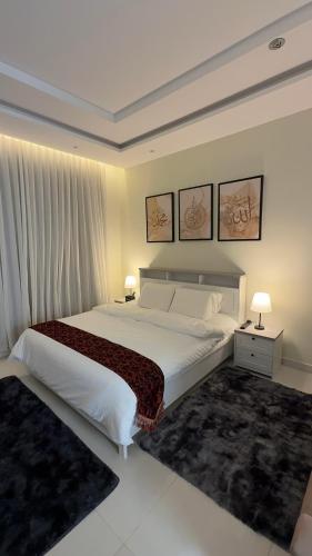 a bedroom with a large white bed with two lamps at دار طيبة in Medina