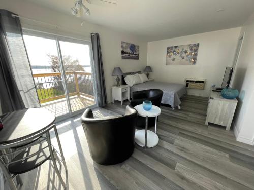 a bedroom with a bed and a balcony at Riverfront Studios Inn in Sault Ste. Marie