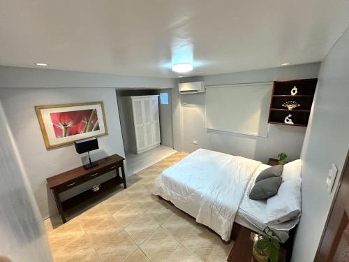 a bedroom with a bed and a desk with a laptop at Evergreen Private Pool Villa - Cavite in General Trias