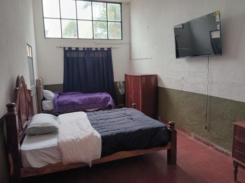 a bedroom with two beds and a tv on the wall at SB hostel in La Rioja