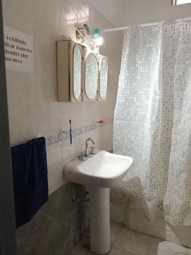 a bathroom with a sink and a shower curtain at SB hostel in La Rioja
