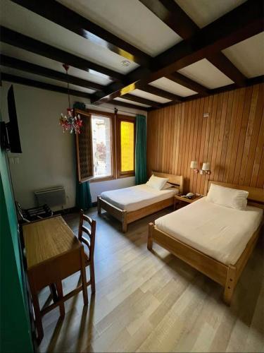 a bedroom with two beds and a table and a desk at Hotel Vegas in Santiago