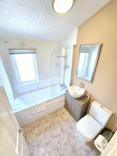 a bathroom with a toilet and a sink and a shower at Birchington Vale - Delta Lodge in Kent